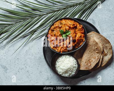 Indische Gerichte: tikka Masala, Reis, Samosa, Chapati, . Indisches Essen auf grauem Steinhintergrund mit Kopierraum. Auswahl indischer Gerichte mit Blick von oben oder Stockfoto