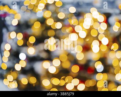 Weihnachten und frohes neues Jahr, verschwommenes Bokeh. Authentische Aufnahme von farbenfrohem Licht auf dem Weihnachtsbaum im Freien mit Bokeh. Wunderschönes weihnachtsbokeh im Hintergrund Stockfoto