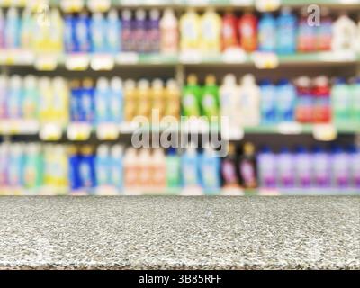 Marmorbrett leerer Tisch vor verschwommenem Hintergrund. Perspektivischer Marmor über farbigen Supermarktprodukten in den Regalen. Modell für Anzeige oder Stockfoto
