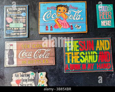 Eine Kollektion farbenfroher Vintage-Schilder zeigt legendäre Charaktere und Marken wie Betty Boop und Coca Cola Stockfoto