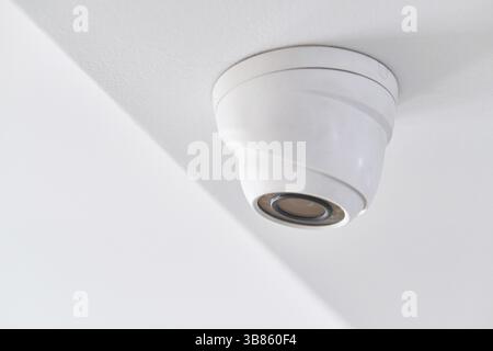 Videoüberwachung an der weißen Decke in einem modernen Gebäude Stockfoto
