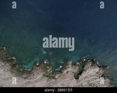 Meereswellen Rollen auf einem felsigen, eingezogenen Ufer. Drohne. Stockfoto