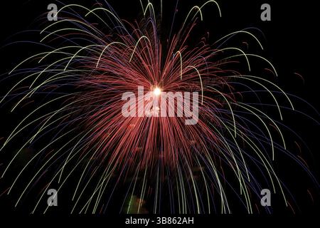 Wunderschönes buntes Feuerwerk am schwarzen Himmel Stockfoto