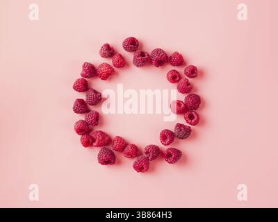 Kreatives Layout mit frischen reifen Beeren. Himbeere auf rosa Hintergrund mit runden leeren Kreis in der Mitte für Kopierraum. Kann für Ihr Design verwenden. Oben V Stockfoto