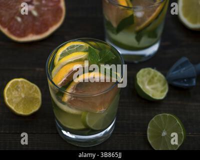 Kalte hausgemachte Limonade mit frischer Zitrone, Limone, Grapefruit und Minze, Zitrone Reibahle. Sommer Drink auf dunklem Hintergrund Stockfoto