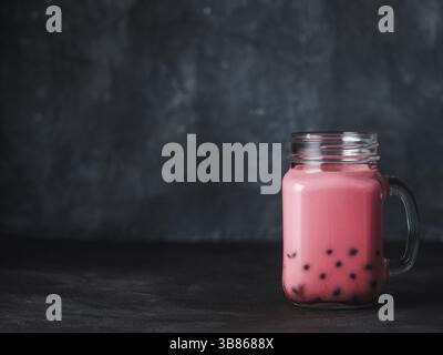 Hausgemachte Milch Bubble Tea mit Tapioka Perlen Kugeln. Beliebte Taiwan Bubble Tea in Glas Marmeladenglas mit Kopie Platz für Text. Bubble Tea auf dunklen backgrou Stockfoto