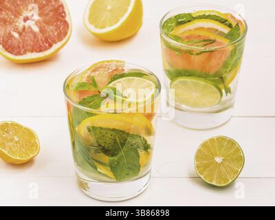 Kalte hausgemachte Limonade mit frischer Zitrone, Limone, Grapefruit und Minze. Sommer trinken auf weißem Holz- Hintergrund Stockfoto