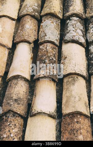 Die Textur der alten braunen Schindeln auf dem Dach des Gebäudes. Stockfoto