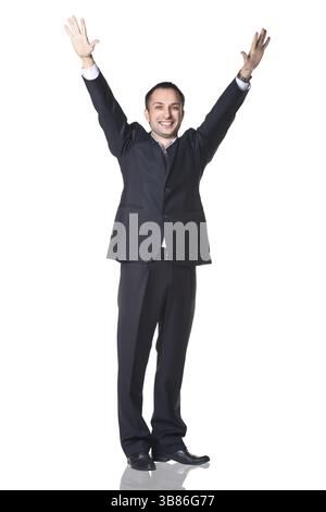 Überraschter Mann, der mit erhobenen Händen lächelt, isoliert über weißem Hintergrund Stockfoto