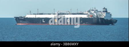 Großer LNG-Träger, der Flüssigerdgas über offene Meeresgewässer in der Nähe von Küstenregionen transportiert Stockfoto