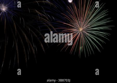 Wunderschönes buntes Feuerwerk am schwarzen Himmel Stockfoto