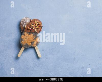 Chia-Eis mit rohen Karottenkuchen und Schokolade auf blauem Hintergrund. Gesundes Rezept und Idee hausgemachtes veganes Eis. Osterdessert-Idee. C Stockfoto