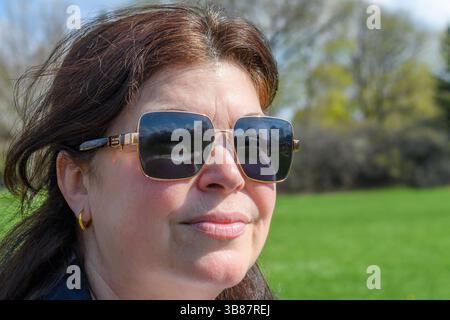 Kopfaufnahme einer Frau mittleren Alters in einem öffentlichen Park. Stockfoto