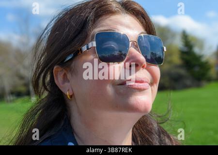 Kopfaufnahme einer Frau mittleren Alters in einem öffentlichen Park. Stockfoto