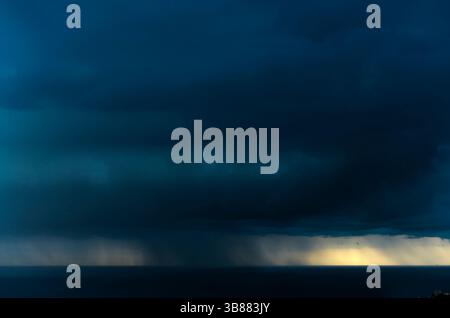 WOLKENBRUCH VON DER REGENWOLKE ÜBER DEM LEEREN RUHIGEN MEER LLORET DE MAR COSTA BRAVA GERONA KATALONIEN SPANIEN Stockfoto