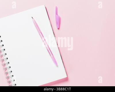 Blick von oben auf die leere Notiz Papier mit Stift auf Rosa pastell Hintergrund. Kopieren Sie Platz. Zurück zu Schule und Bildung Konzept Stockfoto