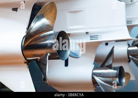 Motorpropeller für Motoryachten und Boote in Nahaufnahme. Die Motoren sind am Heck des Motorbootes montiert. Reparieren Sie ein Boot in einem Trockendock. Stockfoto