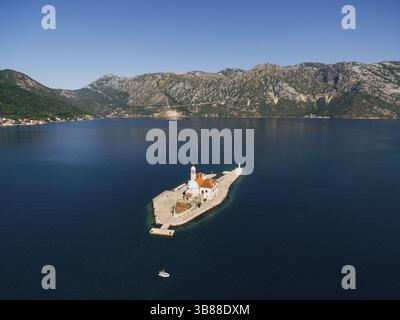 Insel Gospa od Skrpjela in der Bucht von Kotor mit Bergen im Hintergrund. Montenegro. Stockfoto