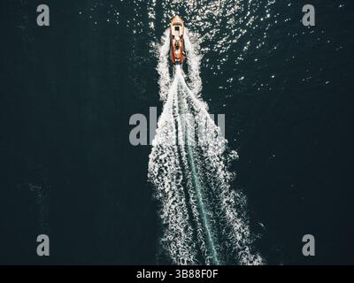 Das Motorboot schneidet durch das Meerwasser. Drohnenfoto, Draufsicht. Stockfoto