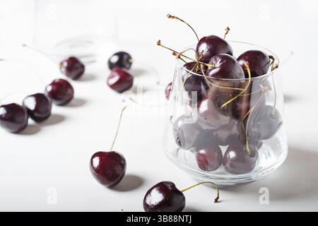 Süße Kirschen in Kirschglas Schüssel um weiß. Nahaufnahme Stockfoto