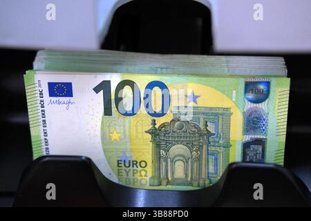 Nahaufnahme, Stapel mit 100-Euro-Banknoten in einem Tablett eines Währungszählgeräts. Finanztransaktionen und wirtschaftliches Konzept Stockfoto