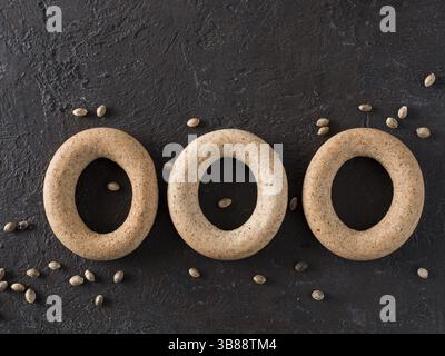 Ringförmiges Knackkorn mit Hanfsamen und Hanfsamen auf schwarzem Hintergrund. Ringförmiges Knackkorn aus nächster Nähe. Kopierbereich Draufsicht oder flach l Stockfoto