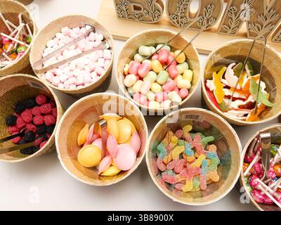 Farbenfrohe Hochzeitsbar mit verschiedenen Süßigkeiten in Gläsern, wunderschön eingerichtet für Gäste, die an der Feier des Empfangs teilnehmen können. Stockfoto