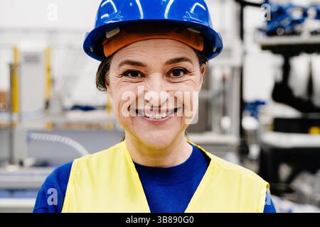 Reife Ingenieurin, die in einer Roboterfabrik, in der Geschäftsindustrie, im Technologiekonzept arbeitet. Konzentrieren Sie sich auf das Gesicht Stockfoto