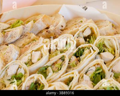 Mini-Schinken- und Salatwickel werden als kalte Vorspeisen an einem Hochzeitsbuffet serviert, perfekt für Cocktailstunden oder Empfangserhaltung. Stockfoto