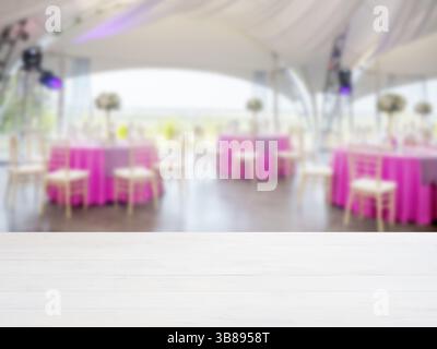 Weißer leerer Holztisch vor dem verschwommenen Hintergrund des Restaurants. Perspektivische weiße Holztafel über Unschärfe im Restaurant oder Café - Mockup für Stockfoto