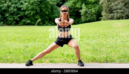 Eine Frau mit konzentrierter Passform in Sportbekleidung macht Outdoor-Workout im Stadtpark Stockfoto