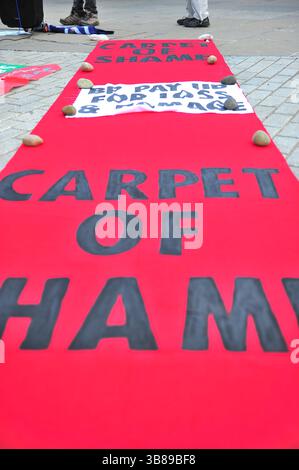 Edinburgh, Großbritannien. Am 13. März 2025 rollten Demonstranten einen Teppich namens The Carpet of Shame vor dem schottischen Parlamentsgebäude aus. Aktivisten versammelten sich vor dem schottischen Parlament, um sich gegen einen BP-Empfang zu wehren und kritisierten die Expansion des Unternehmens mit fossilen Brennstoffen, die Abkehr von Klimaversprechen und die Ölversorgung Israels. Sie drängten die MSPs, Lobbyarbeit von Unternehmen abzulehnen und einen gerechten Übergang zu erneuerbaren Energien zu unterstützen. Stockfoto