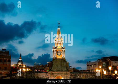 Foto während der blauen Stunde in Cartagena, Kolumbien, mit dem beleuchteten historischen Uhrenturm und der lebhaften Kolonialumgebung. Stockfoto