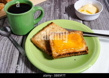 Geröstetes Brot mit Marmelade und einer Tasse Kaffee machen ein köstliches und belebendes Frühstück Stockfoto
