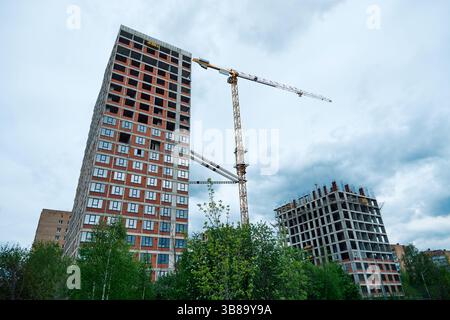 Hochhäuser im Bau und ein Kran gegen den Himmel Stockfoto