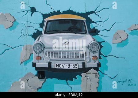 Berühmtes Wandbild eines Trabant-Autos, das durch die Berliner Mauer bricht, gemalt von Birgit Kinder in der East Side Gallery in Berlin. Stockfoto