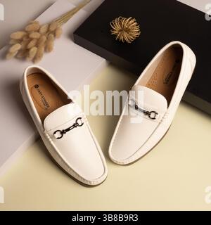 Stylische Slipper aus weißem Leder für Herren mit silberner Schnalle – flach geschnitten Stockfoto