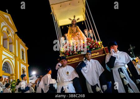 Nazarenos, Gläubige Mitglieder einer religiösen Bruderschaft, tragen während der Karwochenprozession in Mompox, Kolumbien, einen Wagen (paso). Stockfoto