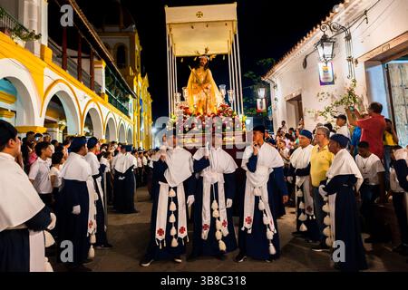 Nazarenos, Gläubige Mitglieder einer religiösen Bruderschaft, tragen während der Karwochenprozession in Mompox, Kolumbien, einen Wagen (paso). Stockfoto