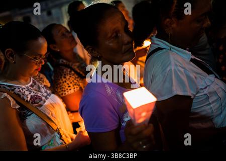Katholische Gläubige, Mitglieder einer religiösen Bruderschaft, tragen während der Karwochenprozession in Mompox, Kolumbien, brennende Kerzen. Stockfoto
