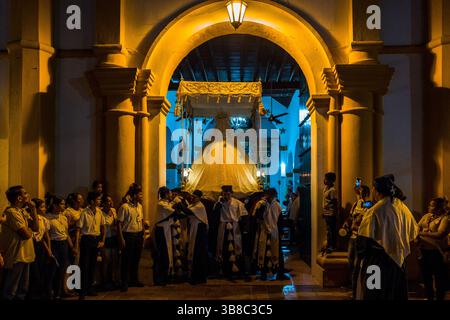Nazarenos, Gläubige Mitglieder einer religiösen Bruderschaft, tragen während der Karwochenprozession in Mompox, Kolumbien, einen Wagen (paso). Stockfoto