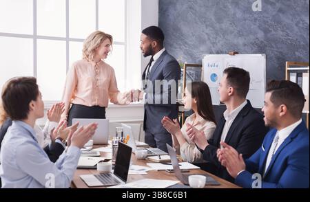 Eine Gruppe fröhlicher Geschäftsleute sitzt beim Meeting Stockfoto