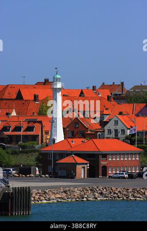 Dänemark, Bornholm Island, Ronne. Leuchtturm und rote Dächer vom Hafeneingang aus gesehen. Stockfoto