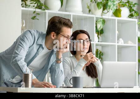 Mann und Frau arbeiten gemeinsam an der Zusammenarbeit von Notebooks, Teamwork im Büro Stockfoto