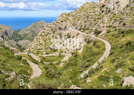 Eine gewundene Bergstraße mit mehreren scharfen Kurven schlängelt sich durch die felsige Landschaft der Tramuntana-Berge auf Mallorca. Balearen, Spanien Stockfoto