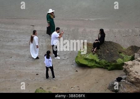 28. April 2024, Bushehr, Iran: Ein iranischer Mann fotografiert eine junge Frau an der Nordküste des Persischen Golfs in der Hafenstadt Bushehr, Provinz Bushehr, Südiranien. Bushehr ist 12 km vom Kernkraftwerk Bushehr entfernt. Das mit russischer Technologie gebaute Kernkraftwerk Bushehr im Iran ist seit 2011 in Betrieb. Es ist die erste zivile Kernkraftanlage im Nahen Osten. (Kreditbild: © Rouzbeh Fouladi/ZUMA Press Wire) Stockfoto