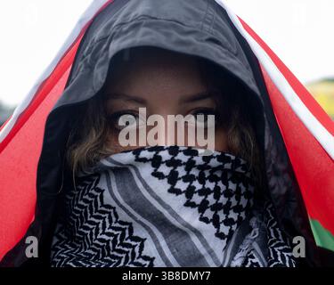 18. Mai 2024, Washington, District of Columbia, USA: Eine Frau, die einen palästinensischen Keffiyeh trägt, hält eine palästinensische Flagge über dem Kopf, während sie an einer pro-palästinensischen Demonstration teilnimmt. Pro-palästinensische Demonstranten versammeln sich in der Washington National Mall, um dann den Nakba-Jahrestag in Washington DC zu feiern. Palästinenser und ihre Anhänger auf der ganzen Welt bezeichneten den 76. Jahrestag der "Nakba", als rund 760.000 Palästinenser während der Gründung Israels 1948 aus ihren Häusern flohen oder vertrieben wurden. (Kreditbild: © Probal Rashid/ZUMA Press Wire) Stockfoto
