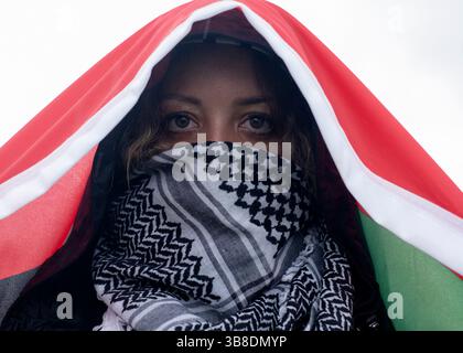 18. Mai 2024, Washington, District of Columbia, USA: Eine Frau, die einen palästinensischen Keffiyeh trägt, hält eine palästinensische Flagge über dem Kopf, während sie an einer pro-palästinensischen Demonstration teilnimmt. Pro-palästinensische Demonstranten versammeln sich in der Washington National Mall, um dann den Nakba-Jahrestag in Washington DC zu feiern. Palästinenser und ihre Anhänger auf der ganzen Welt bezeichneten den 76. Jahrestag der "Nakba", als rund 760.000 Palästinenser während der Gründung Israels 1948 aus ihren Häusern flohen oder vertrieben wurden. (Kreditbild: © Probal Rashid/ZUMA Press Wire) Stockfoto