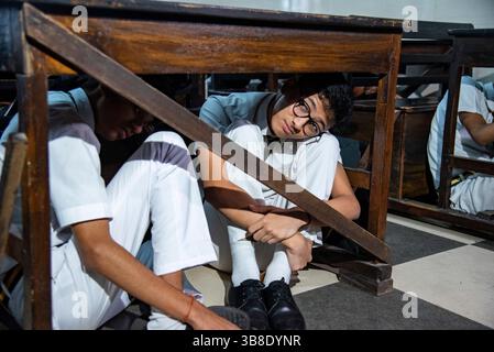 7. Mai 2025, Kolkata, Westbengalen, Indien: Schüler üben das Liegen unter dem Schreibtisch und auf den Bänken während des Sirenengeräusches während der Mock Drill. Indien führt heute in verschiedenen Teilen des Landes Scheinübungen durch, in denen es nach dem tödlichen und feigen Terroranschlag auf Touristen, bei dem 26 Menschen in Pahalgam ums Leben kamen, in der Lage ist, sich in den Beziehungen zwischen Indien und Pakistan zu bewegen. Einige bedeutende Schüler der Schule nahmen zusammen mit ihren Lehrern unter Leitung des zivilschutzministeriums an dieser Scheinübung Teil, gerade am nächsten Tag der Operation Sindoor, die von den indischen Streitkräften bei s durchgeführt wurde Stockfoto
