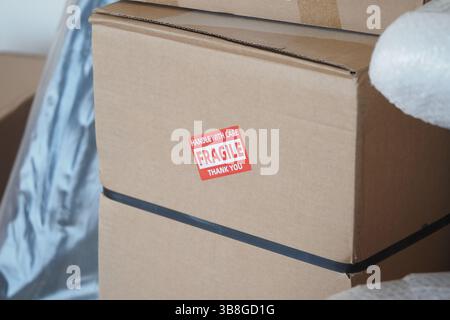 Behutsamer Umgang mit zerbrechlichen Kisten während eines Umzugs in einem neuen Zuhause Stockfoto